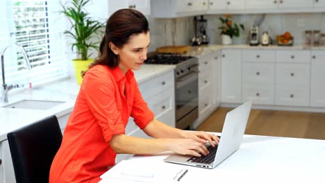 mujer usando portátil en la cocina 4k