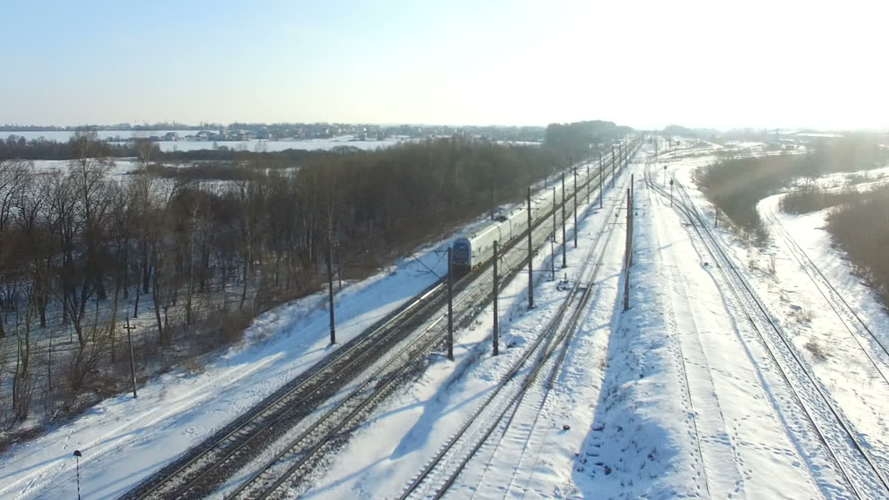 Railway covered with snow. Aerial shot of the train passes on a cold winter landscape