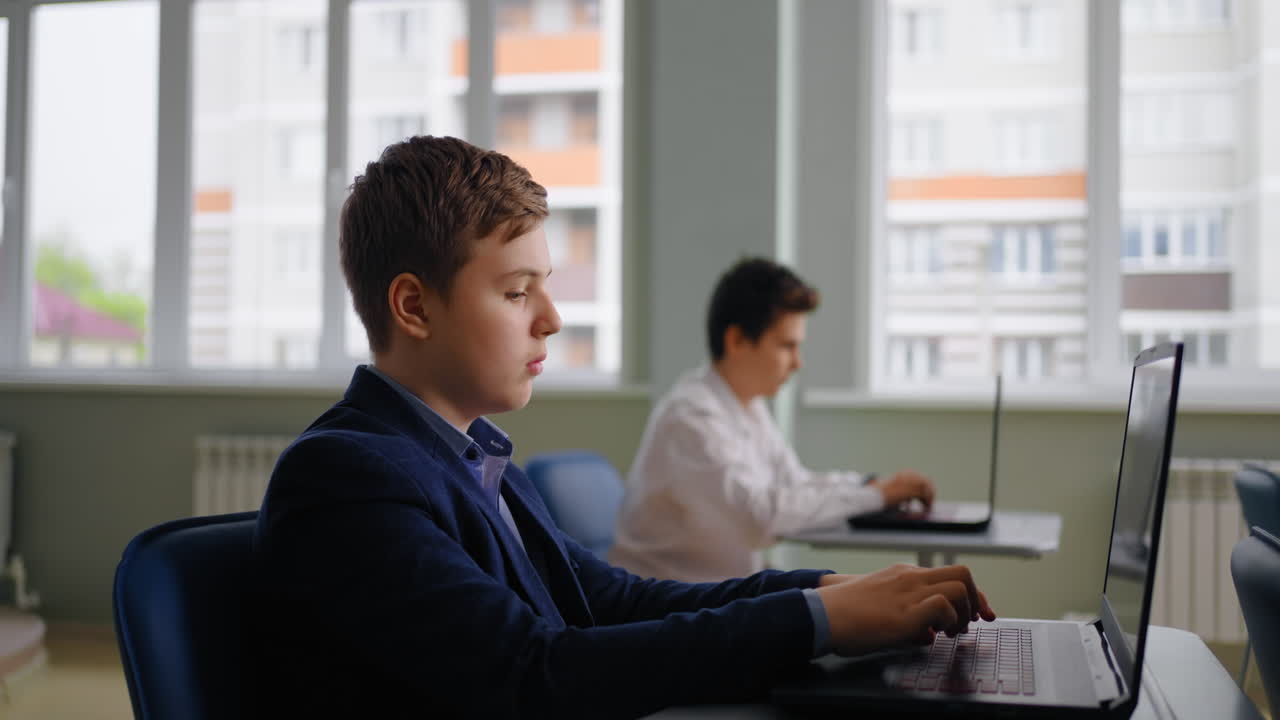 Students working on laptops in a classroom