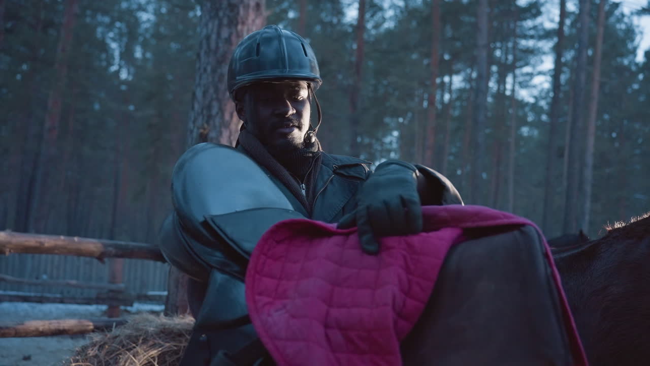 Мужчина внимательно изучает детали седла, всадник с интересом рассматривает кожу и качество изготовления, мужчина едет по зимней сельской местности, тщательно изучая вальтрап и кожаные швы.