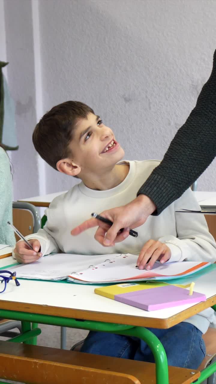 Teacher helping student in classroom