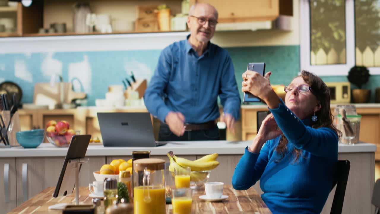 Anciana haciendo tonterías y haciéndose fotos a sí misma en la cocina