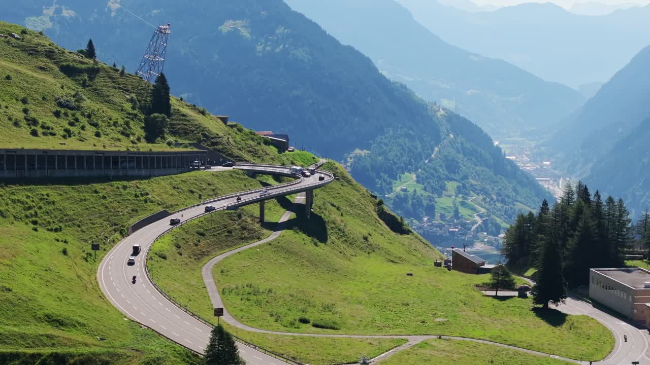 Sweeping alpine road near Airolo curves through green slopes at Gotthard Pass