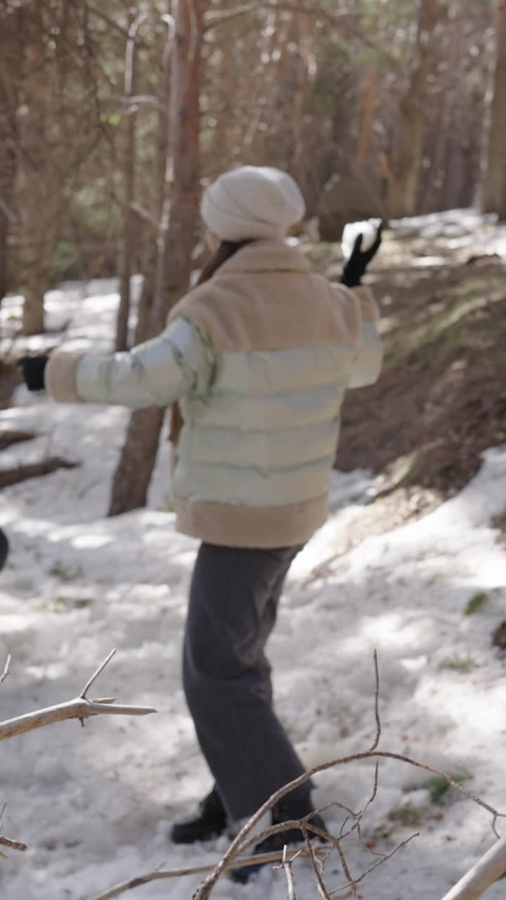 People having a snowball fight in the winter forest