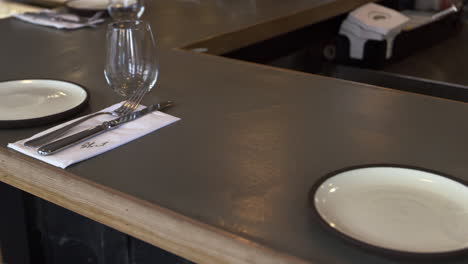 Place-settings-at-bar-in-an-empty-restaurant,-camera-slider