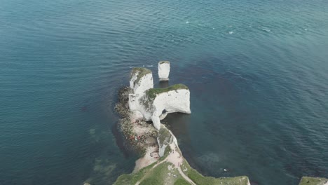 Aufsteigender-Schwenk-Nach-Unten-Drohnenaufnahme-Der-Alten-Kreidefelsen-Von-Harry-Rocks-Vom-Festland-Aus