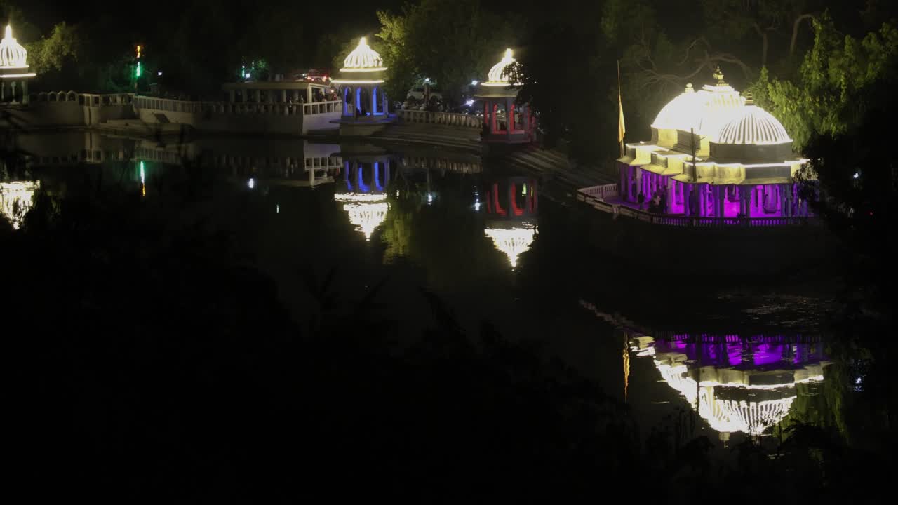historical architecture decorated with ferry colorful lights and water reflection at night video is taken at Udaipur rajasthan india.