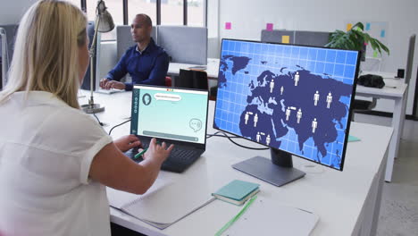 mujer de negocios caucásica usando computadoras con procesamiento de datos en la pantalla en la oficina