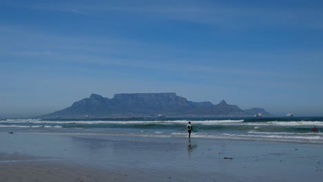surfer with table mountain in the distance