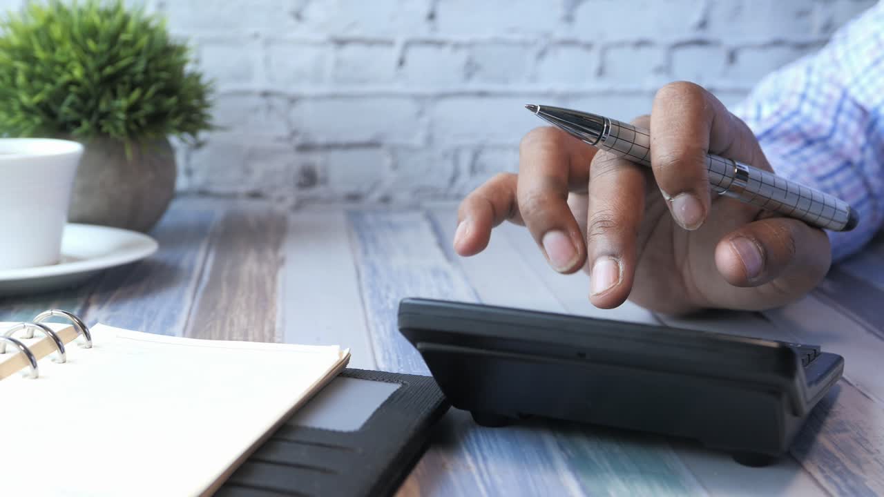 persona que utiliza una calculadora y un portátil