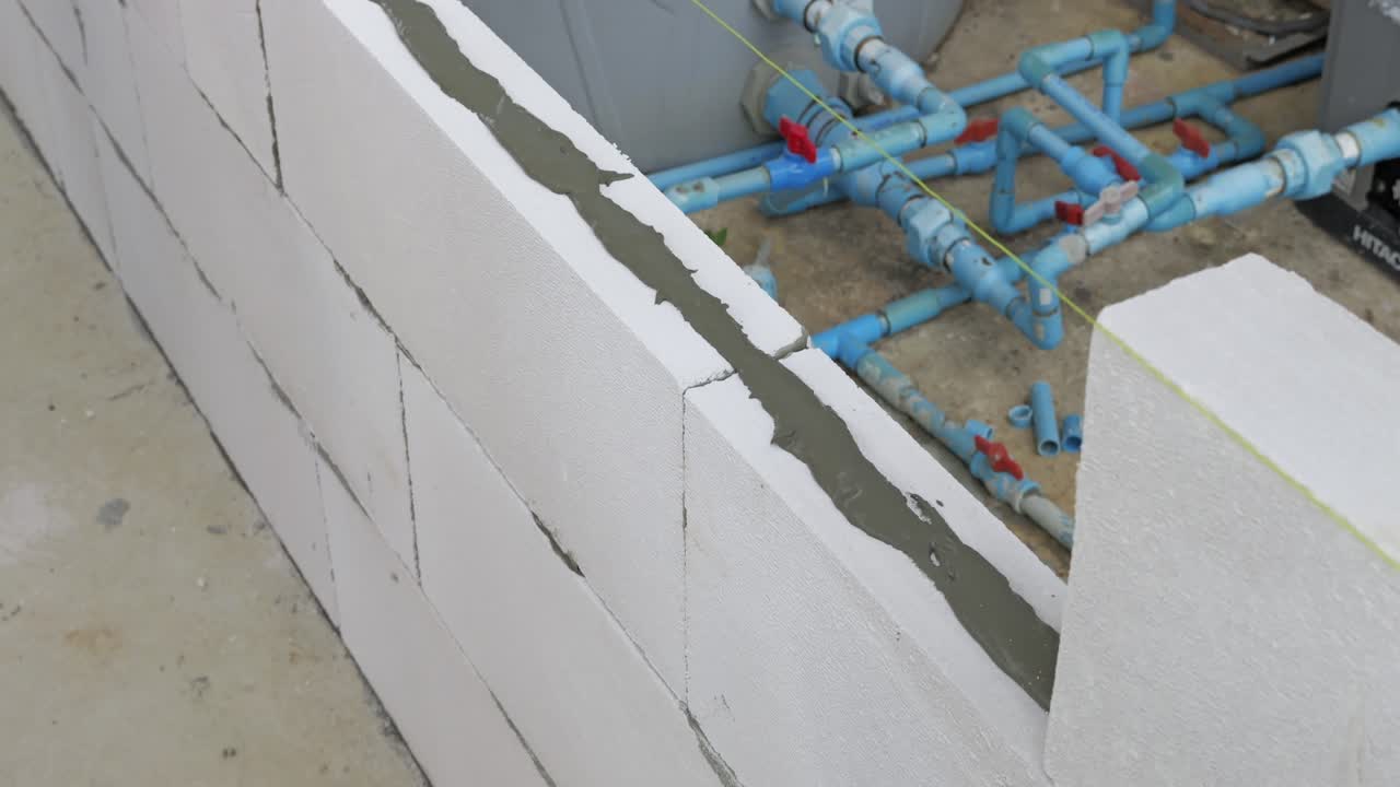 Detailed imagery showcases construction of a wall structure with visible plumbing emphasizing engineering precision