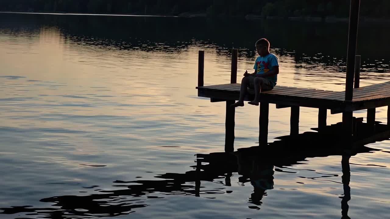 Boy Fishing from a Pier at Sunset