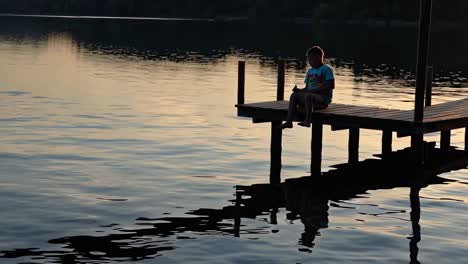 Boy Fishing from a Pier at Sunset