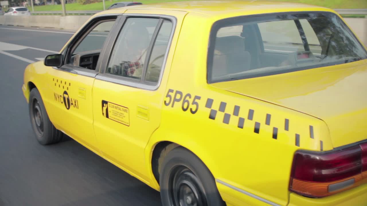 Yellow Taxi Cab Driving on a City Highway During Daytime