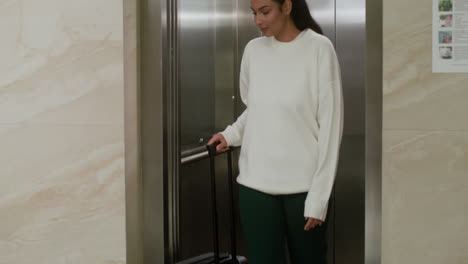 woman exiting the elevator in the hotel hall