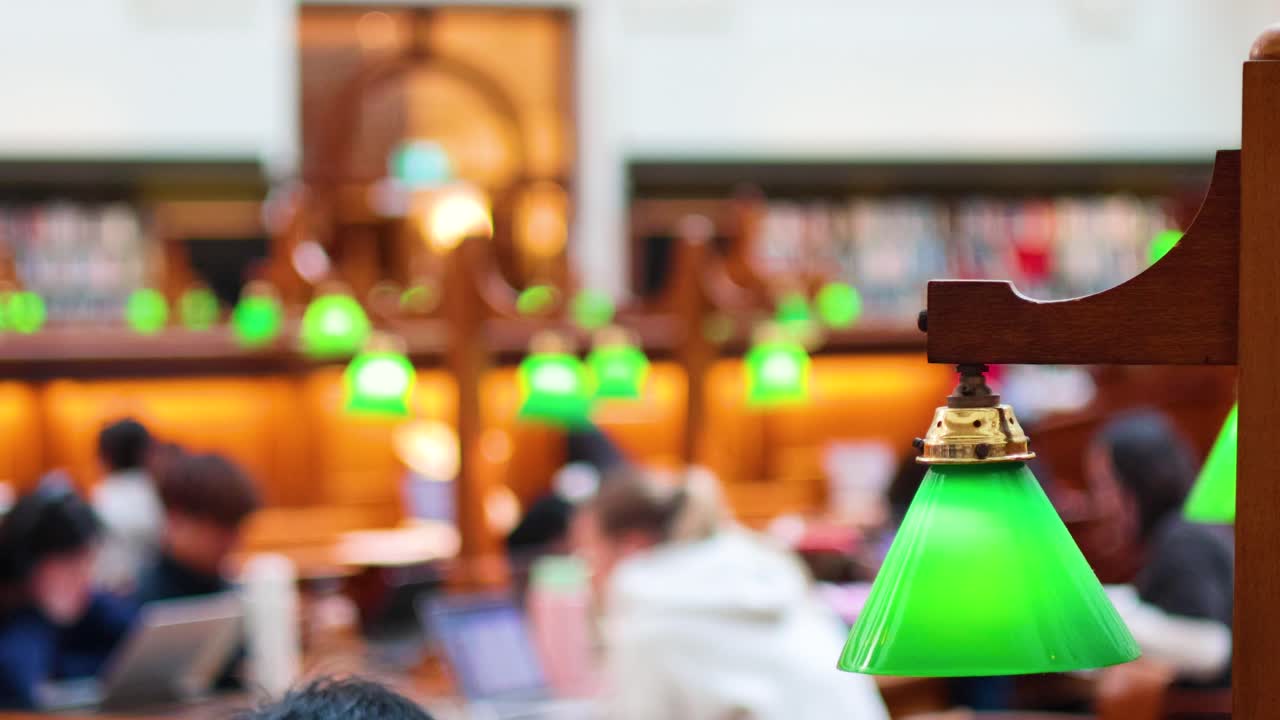 녹색 램프 를 가진 도서관 에서 공부 하는 사람 들