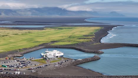 Ferry at a Harbor with Mountains and Black Sand Beach