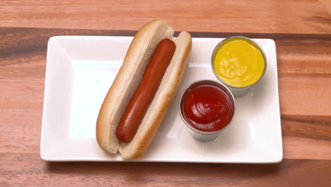 hand taking a hot dog off a plate