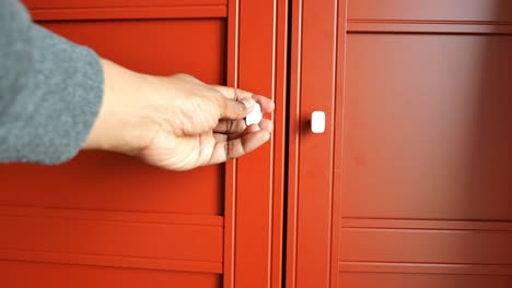persona abriendo una puerta roja