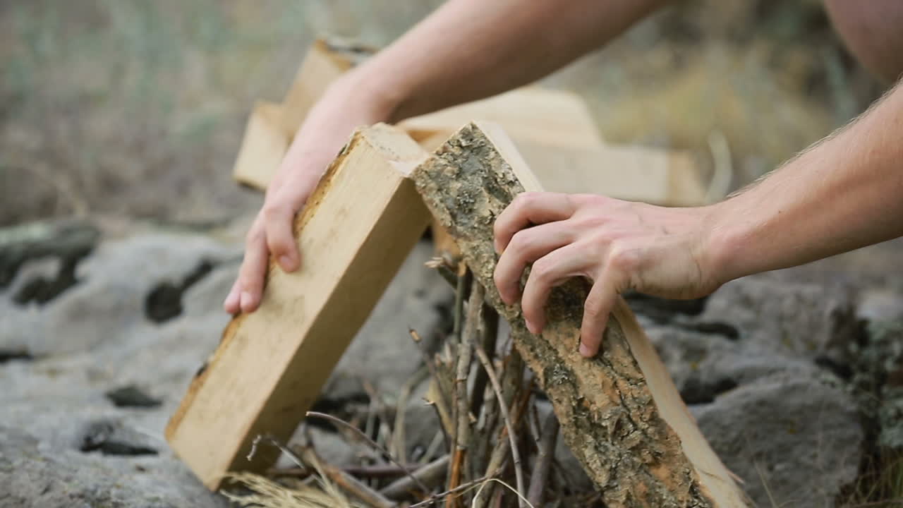 Making Camp Fire In Nature. Young man who making a camp fire in nature