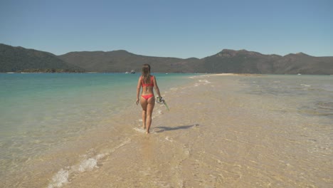 Vista-Posterior-De-Una-Niña-Caminando-Sobre-Un-Banco-De-Arena-En-La-Isla-De-Langford,-Islas-Whitsundays,-Qld-Australia