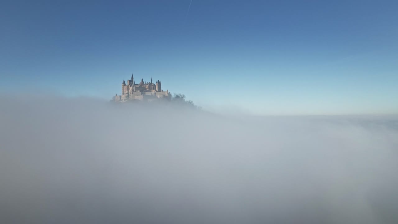 The drone descends as Hohenzollern Castle gradually disappears into the dense clouds, creating a mystical and cinematic view of the German countryside.