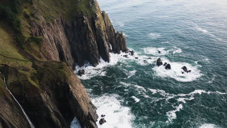 Bird's-eye-view-flying-over-sheer-cliffs-of-Oregon-Coast,-wild-Pacific-Ocean