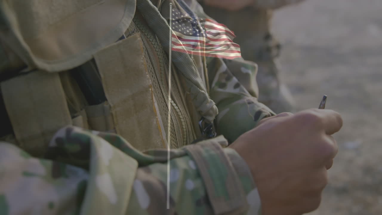 Holding equipment, soldier in camouflage uniform with American flag patch visible