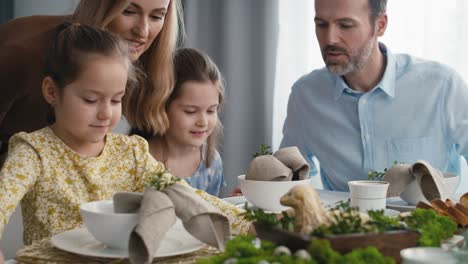 caucasian family of five spending time over table on easter time.