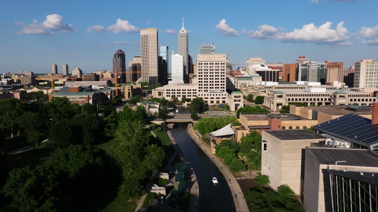 Dolly drone shot flying low along White River Canal toward downtown Indianapolis skyline