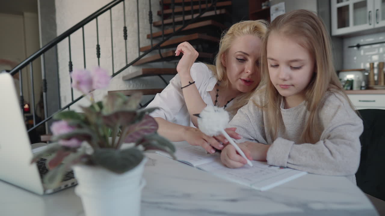 어머니 와 딸 이 집 에서 함께 숙제를 하고 있다