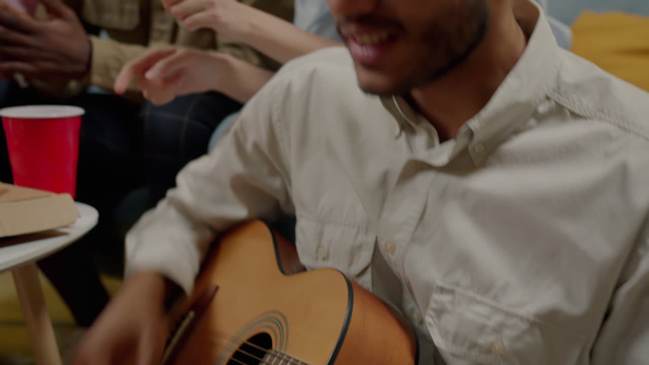 Friends playing guitar at a party