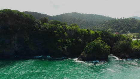 Drone-shot-of-a-cliff-with-a-village-and-beach-in-the-background