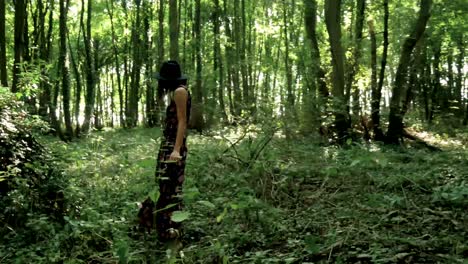 young, trendy woman in long dress twirls in the middle of a forest