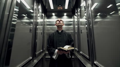 el sacerdote en un ascensor.