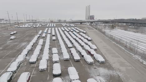 aerial fly over of snow covered cars and assembly plant