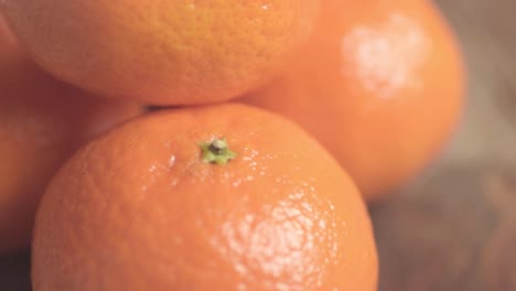 Group-of-clementines-oranges-in-peel-panning-close-up