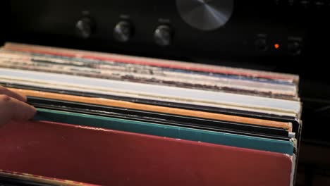 cerrar las manos del hombre hojeando discos de vinilo antiguos en casa