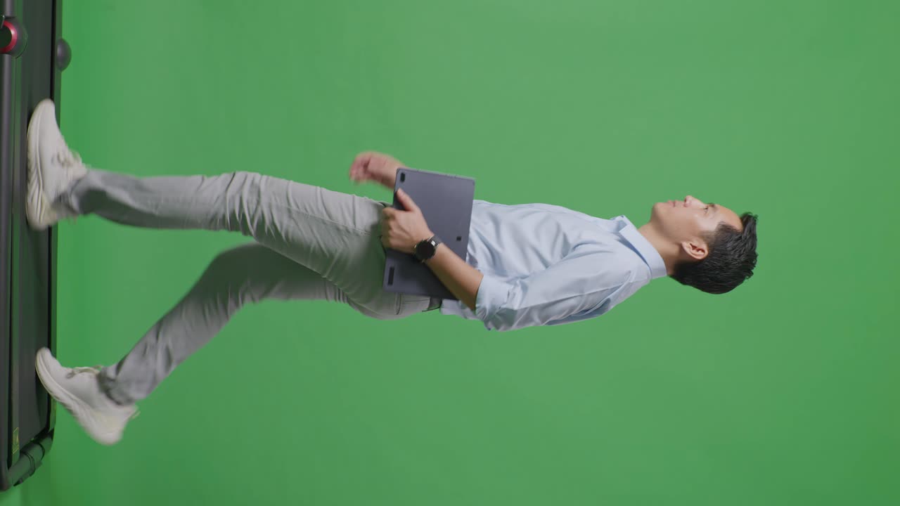 사이드 뷰: 태블릿을 들고 스튜디오에서 녹색 화면 배경에서 는 아시아 사업가의 전체 몸