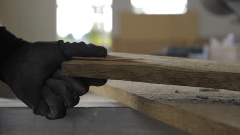 video de primer plano en cámara ultra lenta de un trabajador de la construcción agarrando un trozo de madera