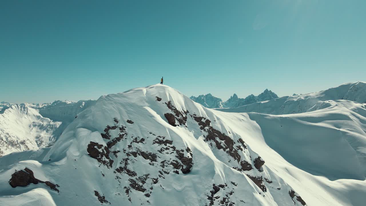 Freerider with the skis on his back on a summit