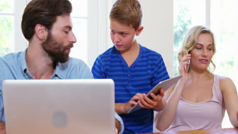 familia linda usando un dispositivo electrónico