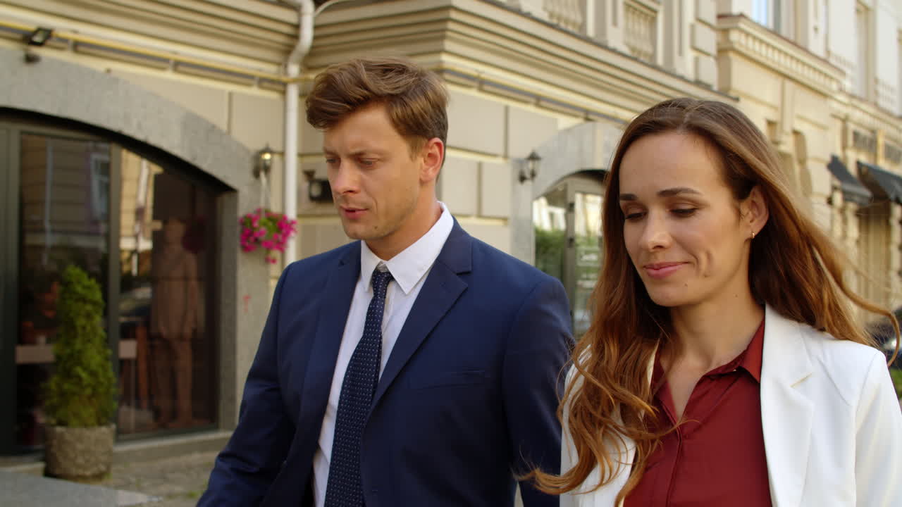 близкий мужчина и женщина обсуждают работу. деловая пара гуляет вместе по тротуару.