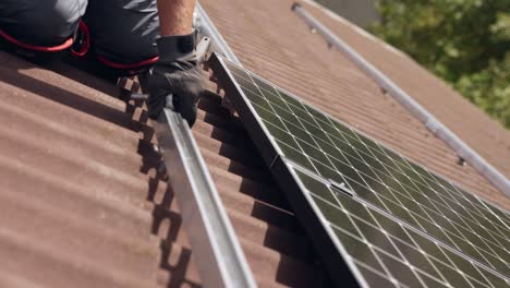 montaje de un nuevo panel solar instalado sobre rieles, primer plano de un trabajador en el techo, día