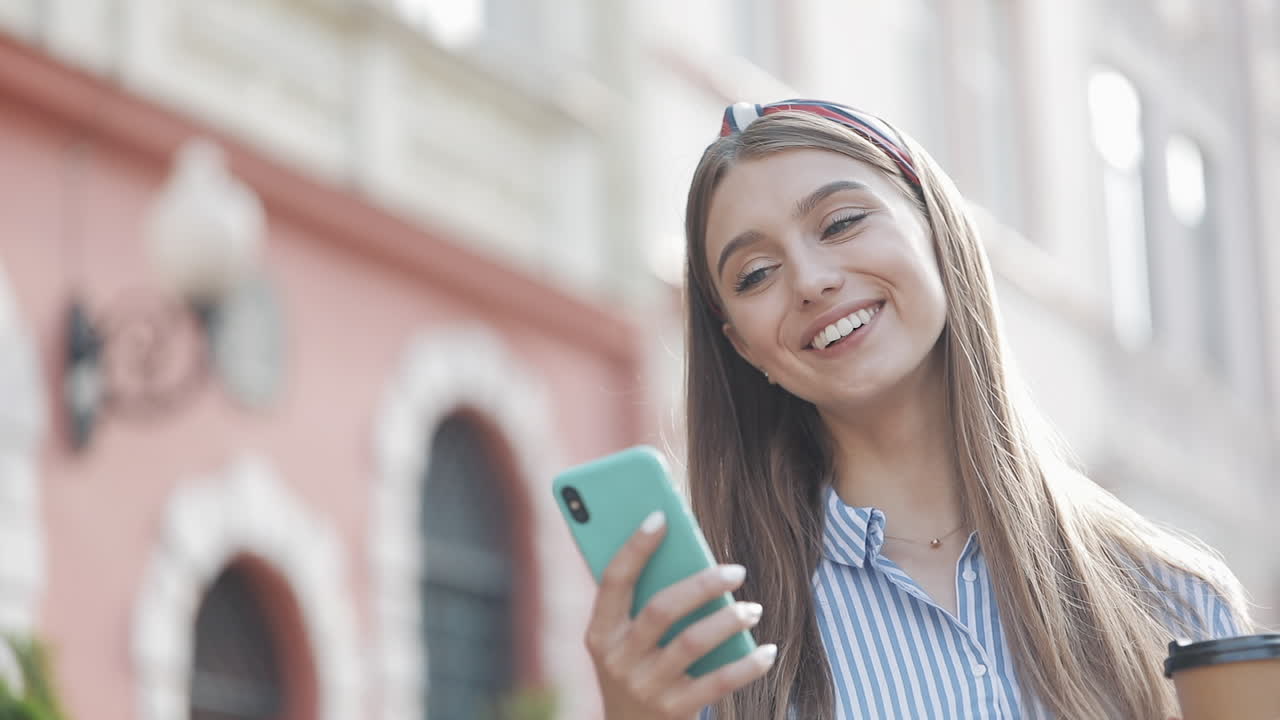 Giovane donna felice che reagisce ai contenuti sul suo smartphone all'aperto