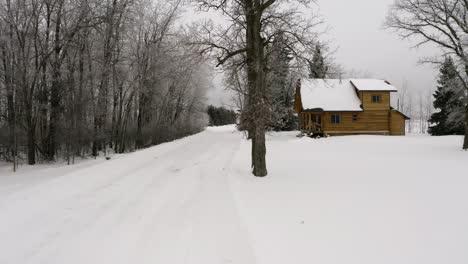 Acercamiento-Lento-A-Una-Hermosa-Cabaña-De-Troncos-Durante-Una-Ligera-Nevada-Invernal