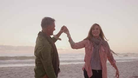 Active-senior-couple-dancing-on-beach