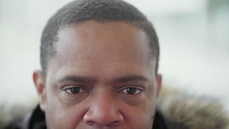 close up shot of afro-american middle-aged mans eyes looking at camera and smiling