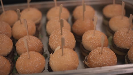 mini burgers on tray with toothpicks