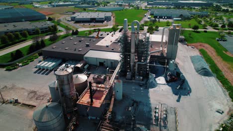 aerial view of large-scale manufacturing plant with silos and processing towers near de perre wisconsin, usa